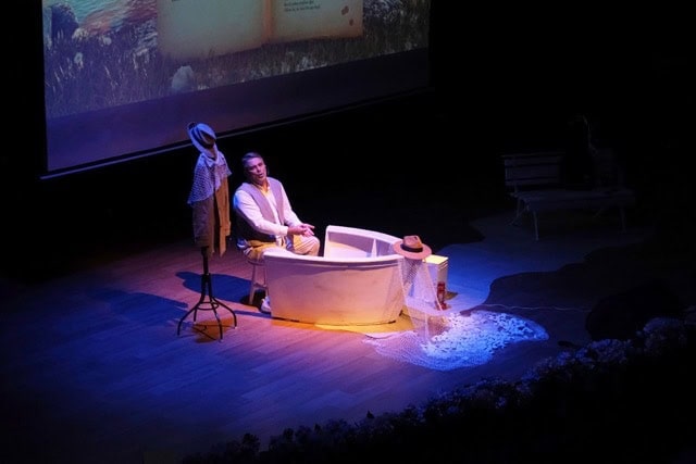 Sahne dekoru ile tatil ve dinlenme temalı oyun veya gösterim, seyirciye ulaşmakta.